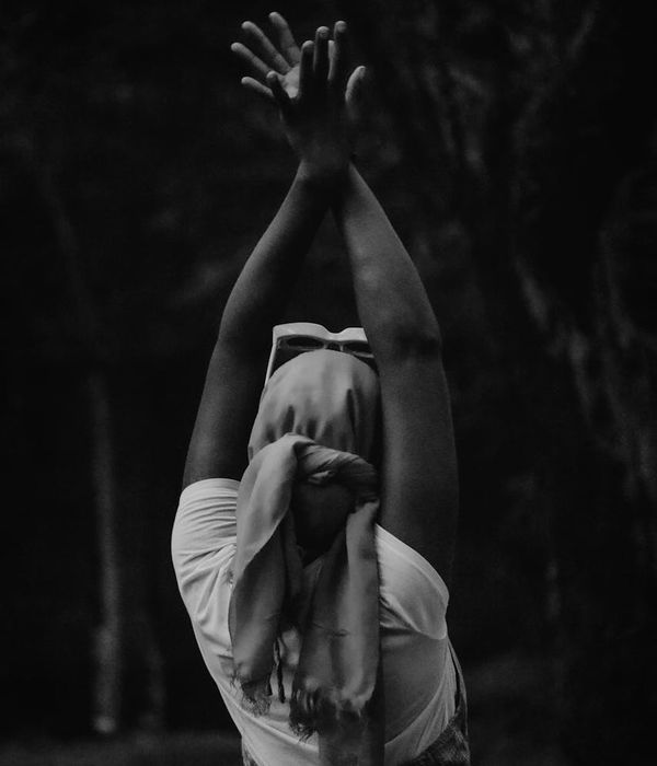 Silhouette of a person in a fluid yoga pose against a calm background.